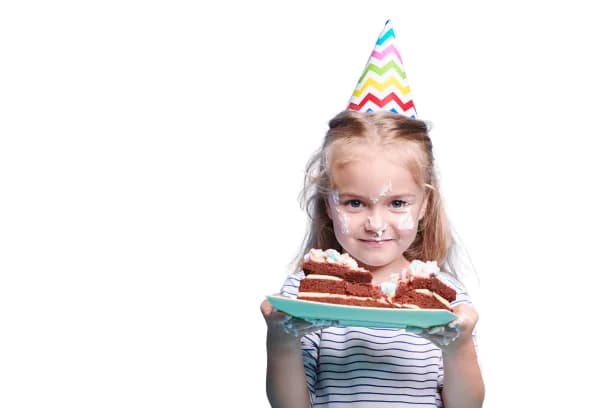 Kid in party hat holding a plate of birthday cake