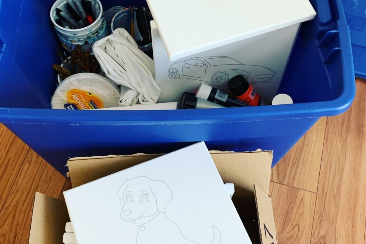 Art party supply bin with pre-sketched canvases and brushes
