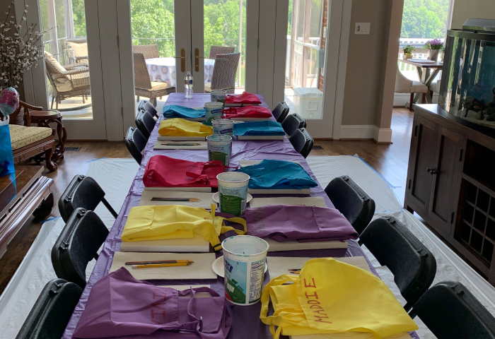 Living room paint party table with colorful aprons and canvases