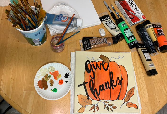 Give Thanks pumpkin canvas painting with art supplies on table